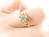 a woman ' s hand holding a ring with a diamond on it