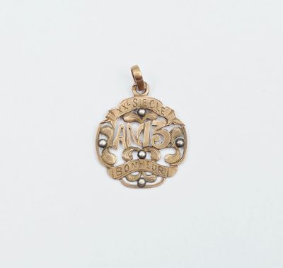 un pendentif plaqué or sur lequel figure le prénom d'une femme inscrit dans un cercle