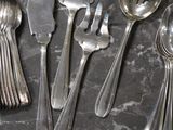 a lot of silver spoons and forks on the table