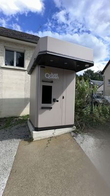 a small toilet in the corner of a small building
