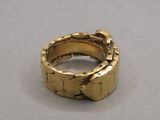 une bague en or ornée d'un nœud, posée sur une table