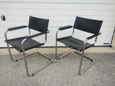 pair of chrome and black leather chairs in front of a garage door