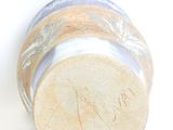 a close up of a vase on a white surface