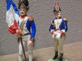 two figurines of a soldier and a soldier holding a flag