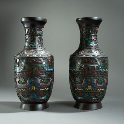 pair of black vases with colorful designs on them sitting on a table