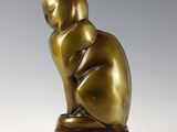 bronze sculpture of a cat sitting on a wooden block