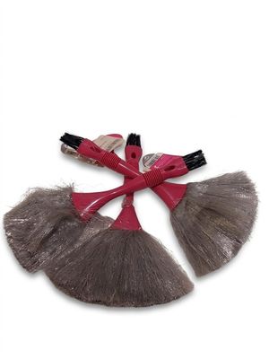 une brosse à cheveux rouge et grise ornée d'un nœud sur le dessus
