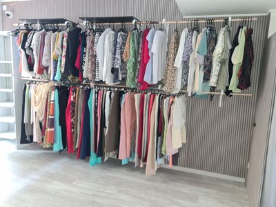 a rack of clothes hanging on a wall in a room