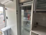 a refrigerator that is in the corner of a room