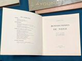 a book open on a blue table with other books on it
