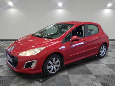 a red car is parked on a checkered floor in a garage