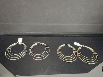 trois paires de boucles d'oreilles créoles en or exposées dans un écrin noir