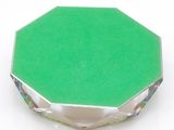a close up of a green object on a white surface
