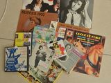 une pile de magazines posée par terre à côté d'un ordinateur portable
