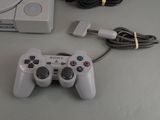 a white game controller sitting next to a charger on a table