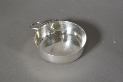 un bol en argent avec une cuillère sur une table