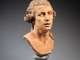 marble bust of a young man with long hair on a pedestal