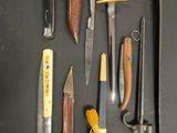 many different types of knives on a black surface