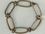 un gros plan d'un bracelet en métal entouré d'une corde