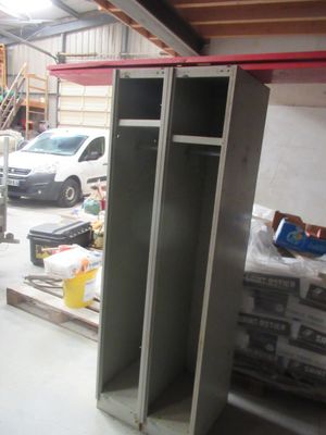 une armoire métallique dans un garage, avec une voiture garée à l'arrière-plan