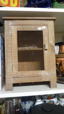 une armoire en bois avec une porte vitrée, posée sur une étagère