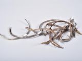 a pile of silverware on a white surface