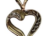 a close up of a heart shaped pendant on a white background