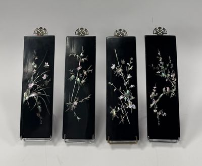 trois vases en noir et blanc ornés de fleurs, posés sur une surface blanche