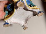 a hand holding a small figurine of a man riding a horse
