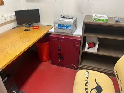 a desk with a computer and a printer in a room
