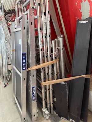 a lot of different types of ladders in a warehouse