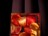 dried rose petals in a glass block on a black background