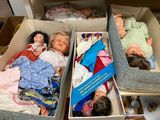two boxes with dolls inside of them on a table
