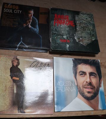 quatre CD posés sur une table, avec un homme en arrière-plan