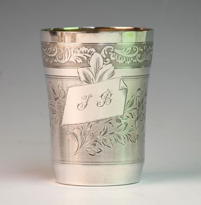 a silver cup sitting on a table with a name tag on it