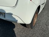 a small white car parked on the side of the road