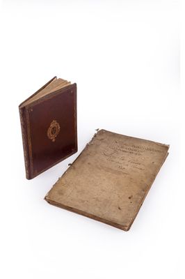 an old book sitting next to an old book on top of a white surface
