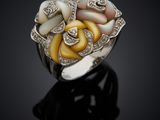 a close up of a ring with mother of pearl and diamonds
