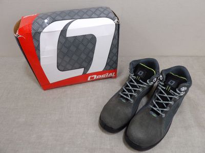 les chaussures se trouvent à côté d'une boîte de chaussures posée par terre