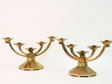 two gold candlesticks on a white background