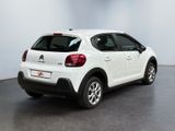 the back of a white citrole parked in a white room