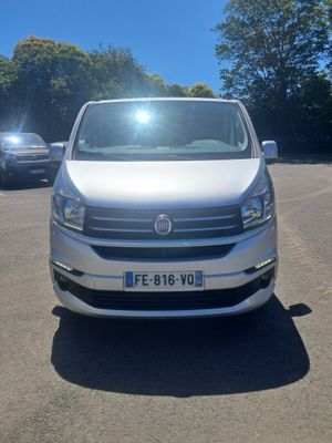 la camionnette blanche est garée dans un parking avec d'autres voitures