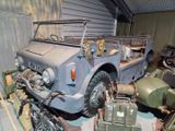 an old military vehicle parked in a garage next to other military vehicles