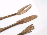three wooden utensils sitting on a white surface