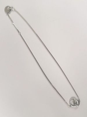 a silver necklace with a circular clasp on a white background