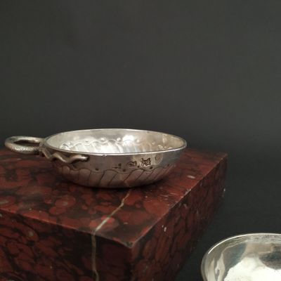 a silver bowl sitting on top of a box next to a silver bowl
