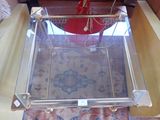 a glass coffee table with a glass top on a rug