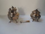 two silver objects sitting on a table next to each other