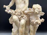 une image représentant une statue d'une femme assise sur un rocher avec deux enfants