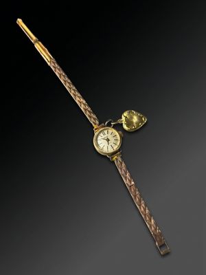 an image of a gold wrist watch with a pen and a clock on it